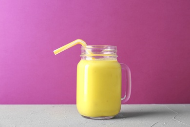 Photo of Mason jar with delicious detox smoothie on table