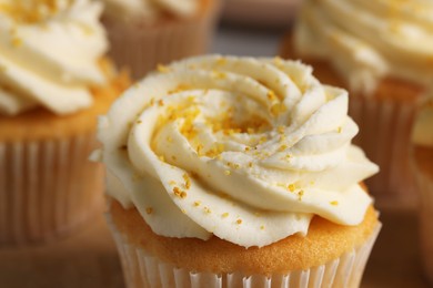 Delicious cupcakes with white cream and lemon zest, closeup