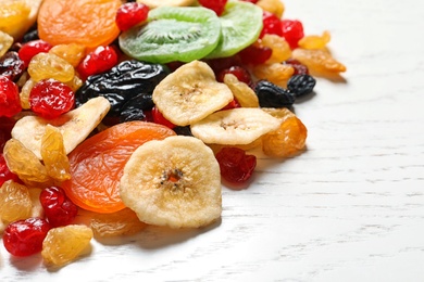 Different dried fruits on wooden background, space for text. Healthy lifestyle