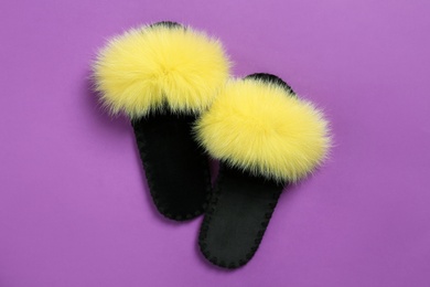 Photo of Pair of soft slippers on violet background, flat lay