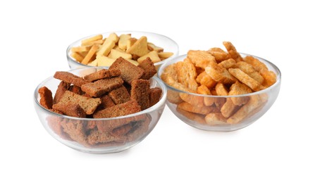 Different crispy rusks in bowls on white background