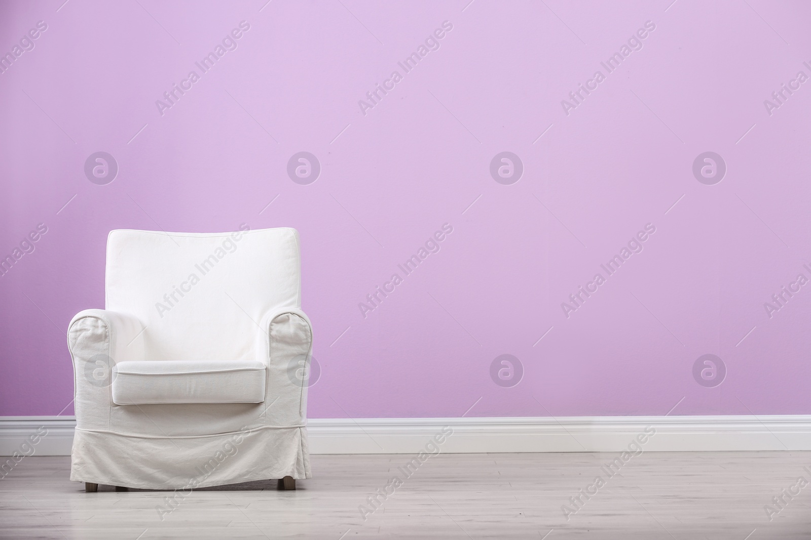 Photo of Stylish comfortable armchair near color wall