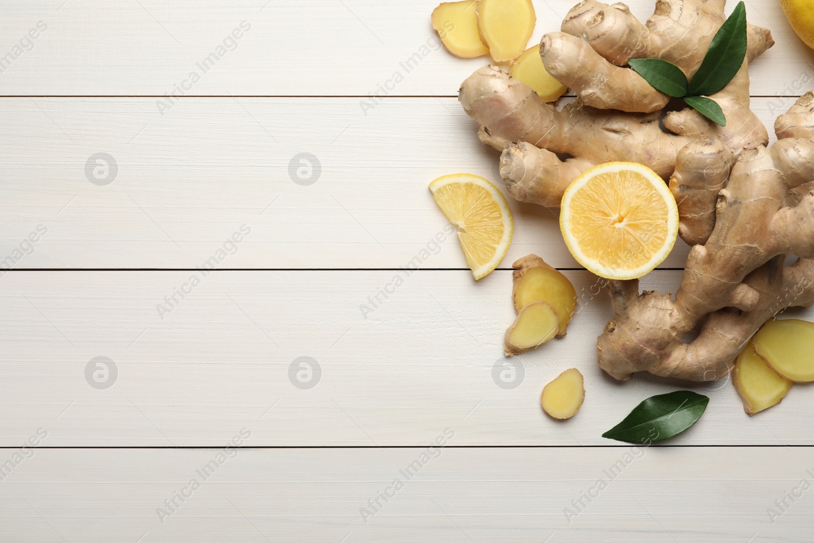 Photo of Fresh lemon and ginger on white wooden table, flat lay. Space for text