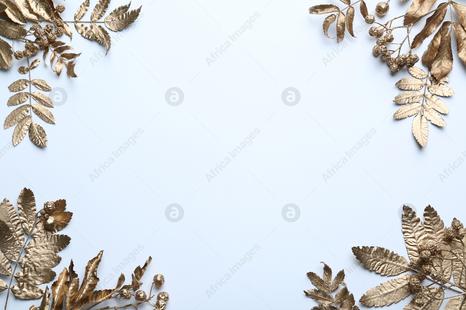 Photo of Frame made of golden rowan leaves and berries on white background, flat lay with space for text. Autumn season