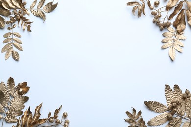 Photo of Frame made of golden rowan leaves and berries on white background, flat lay with space for text. Autumn season