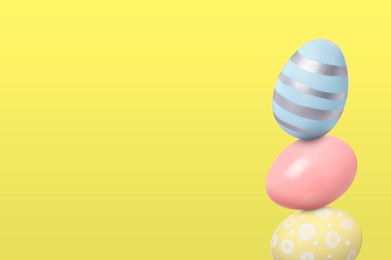 Image of Stack of Easter eggs on light yellow background, space for text
