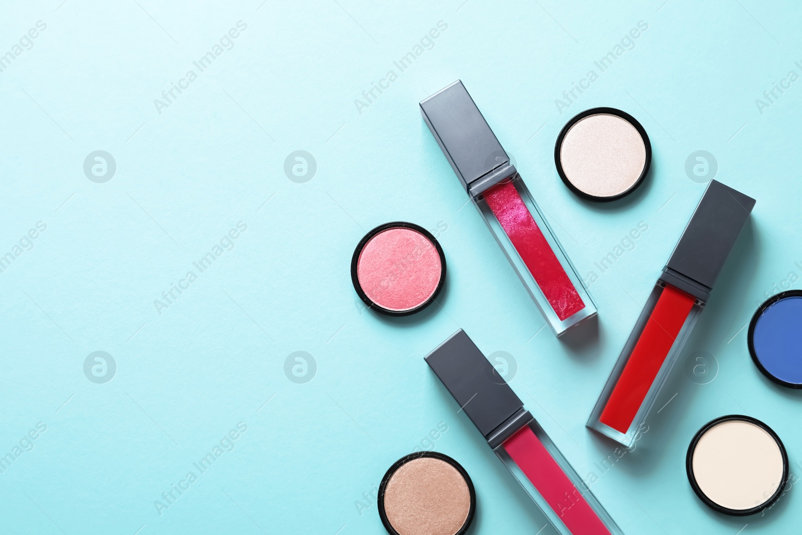 Photo of Composition of lipsticks and eyeshadows on color background, flat lay. Space for text