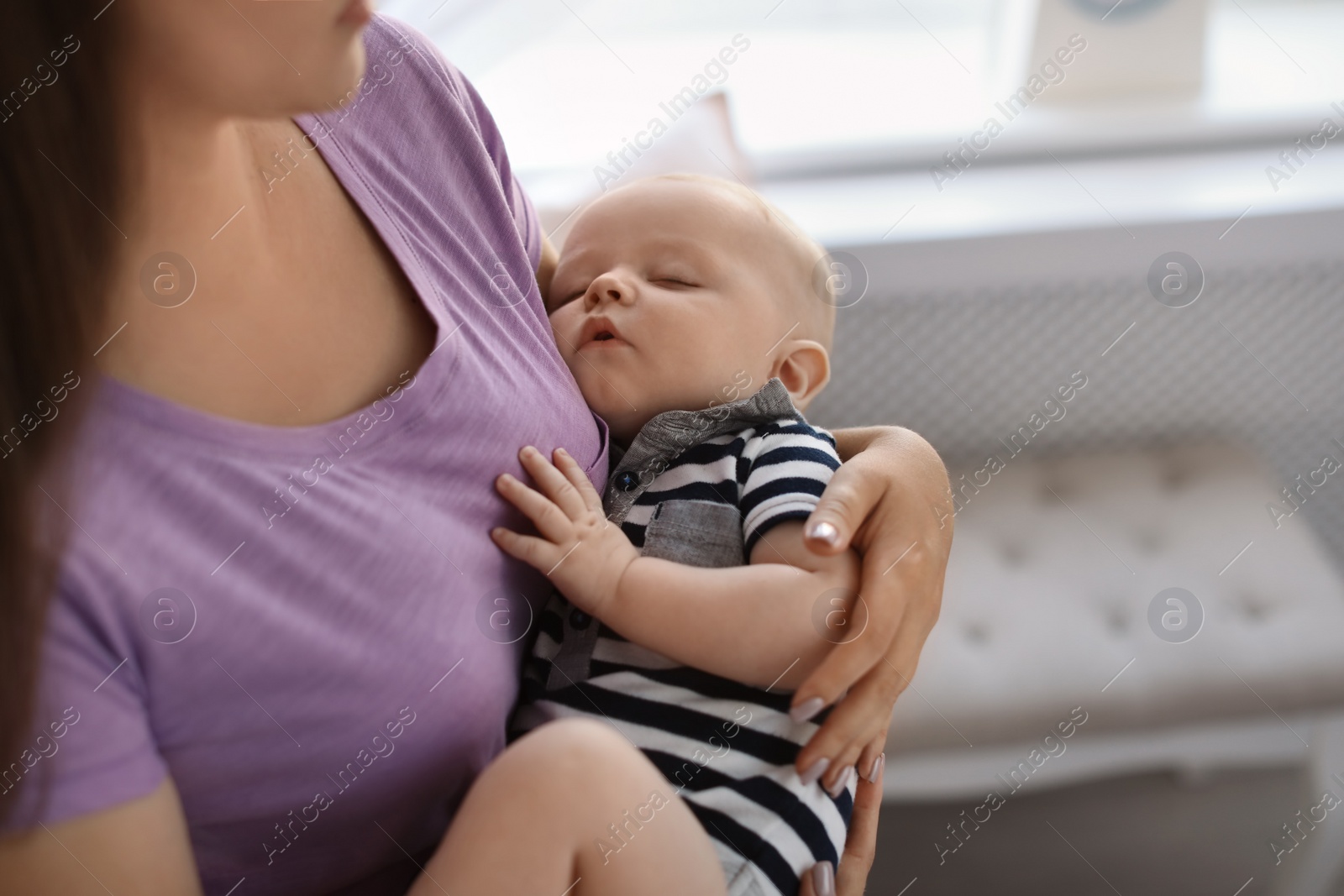 Photo of Mother with her sleeping baby at home, closeup view