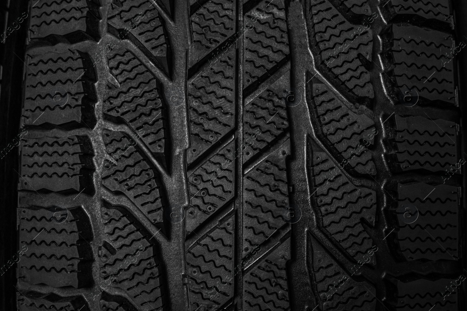 Photo of Winter tire as background, closeup. Car maintenance