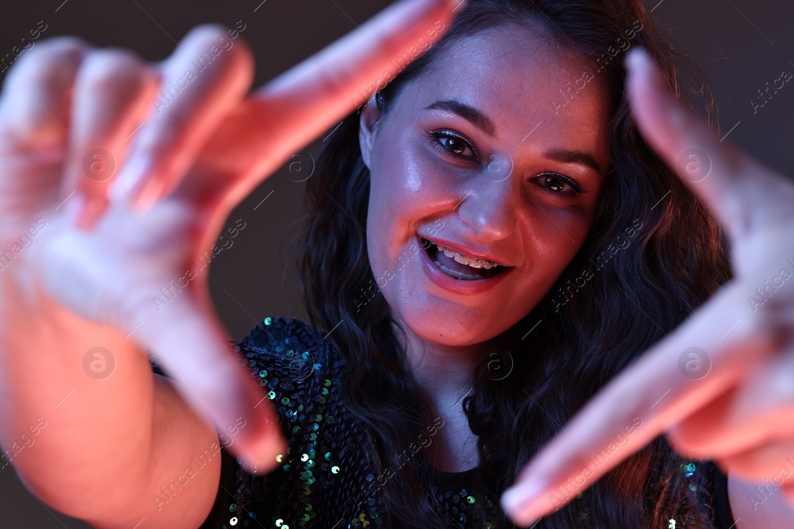 Photo of Portrait of beautiful young woman on color background with neon lights