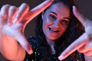 Photo of Portrait of beautiful young woman on color background with neon lights