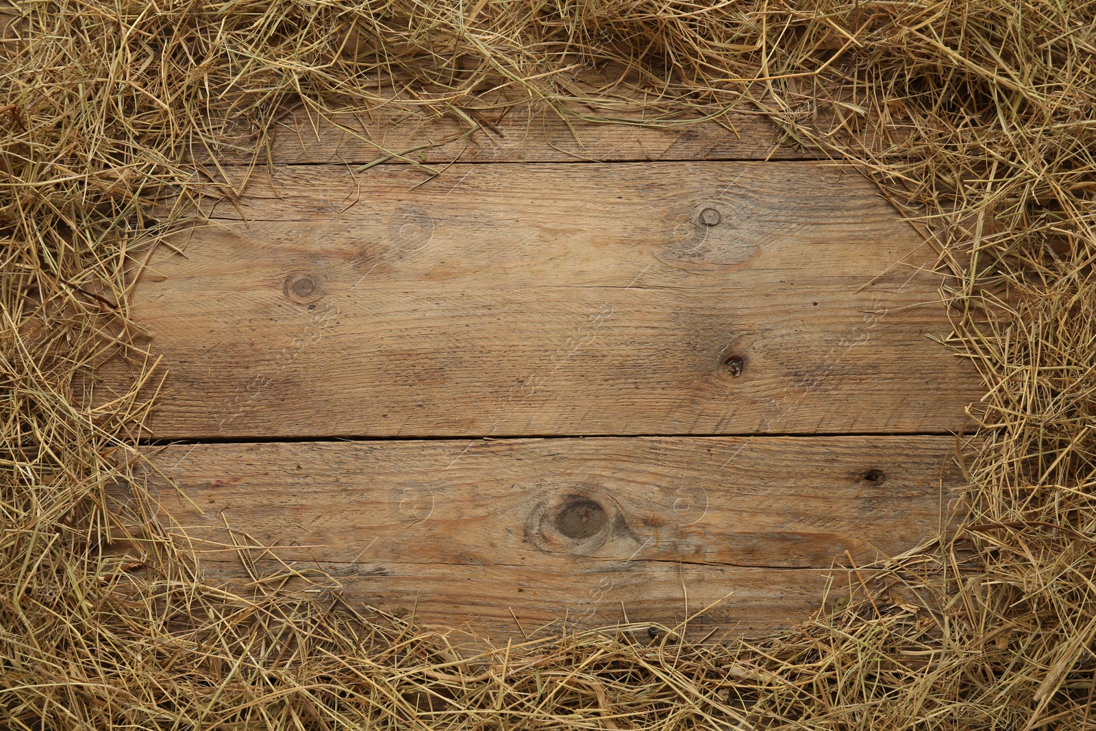 Photo of Frame made of dried hay on wooden background, top view. Space for text