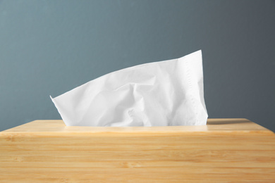 Photo of Wooden box of paper tissues on black background, closeup