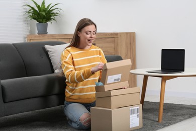 Emotional woman with stack of parcels at home. Online store