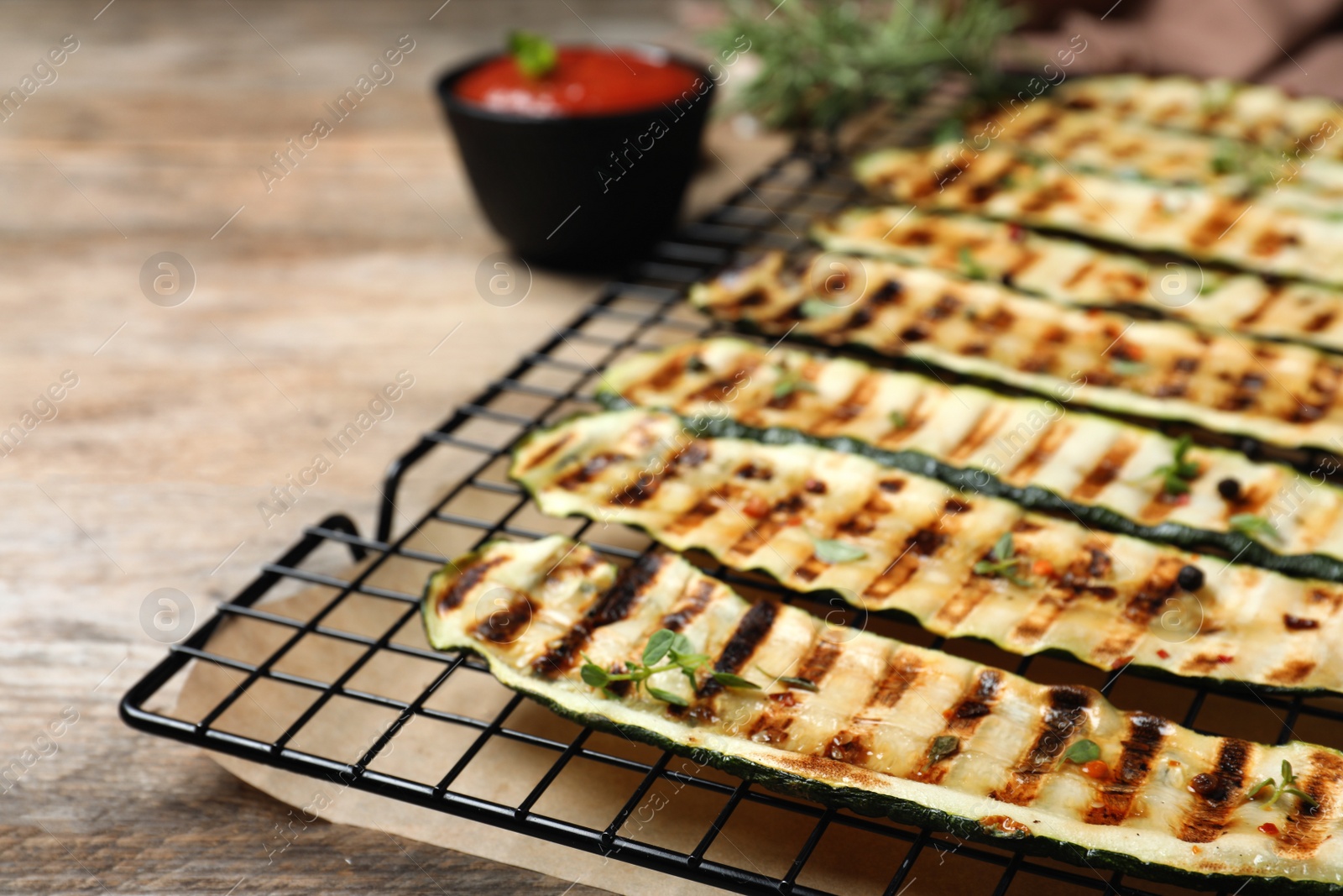 Photo of Grilled zucchini slices on wooden table, closeup