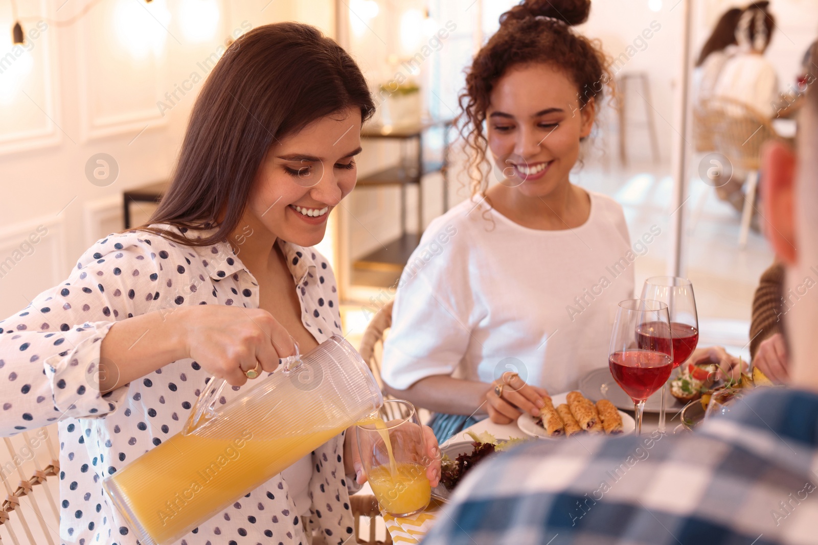 Photo of Group of people having brunch together at table indoors