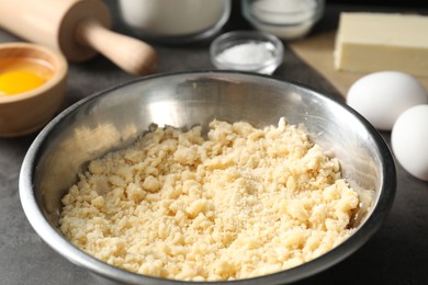 Photo of Shortcrust pastry in bowl on grey table, closeup