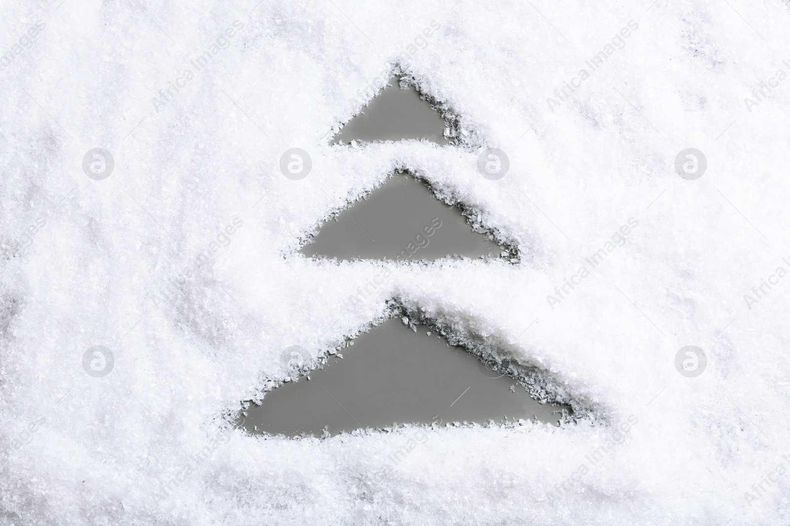 Photo of Christmas tree silhouette in snow on color background, top view