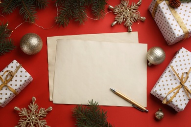 Photo of Flat lay composition with blank sheets of paper on red background, space for text. Writing letter to Santa