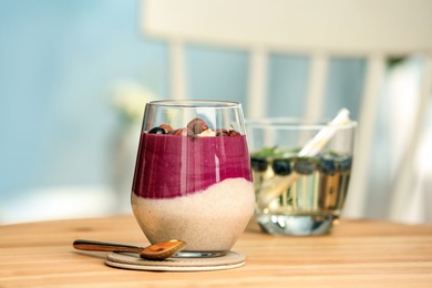 Photo of Glass with tasty acai smoothie on wooden table