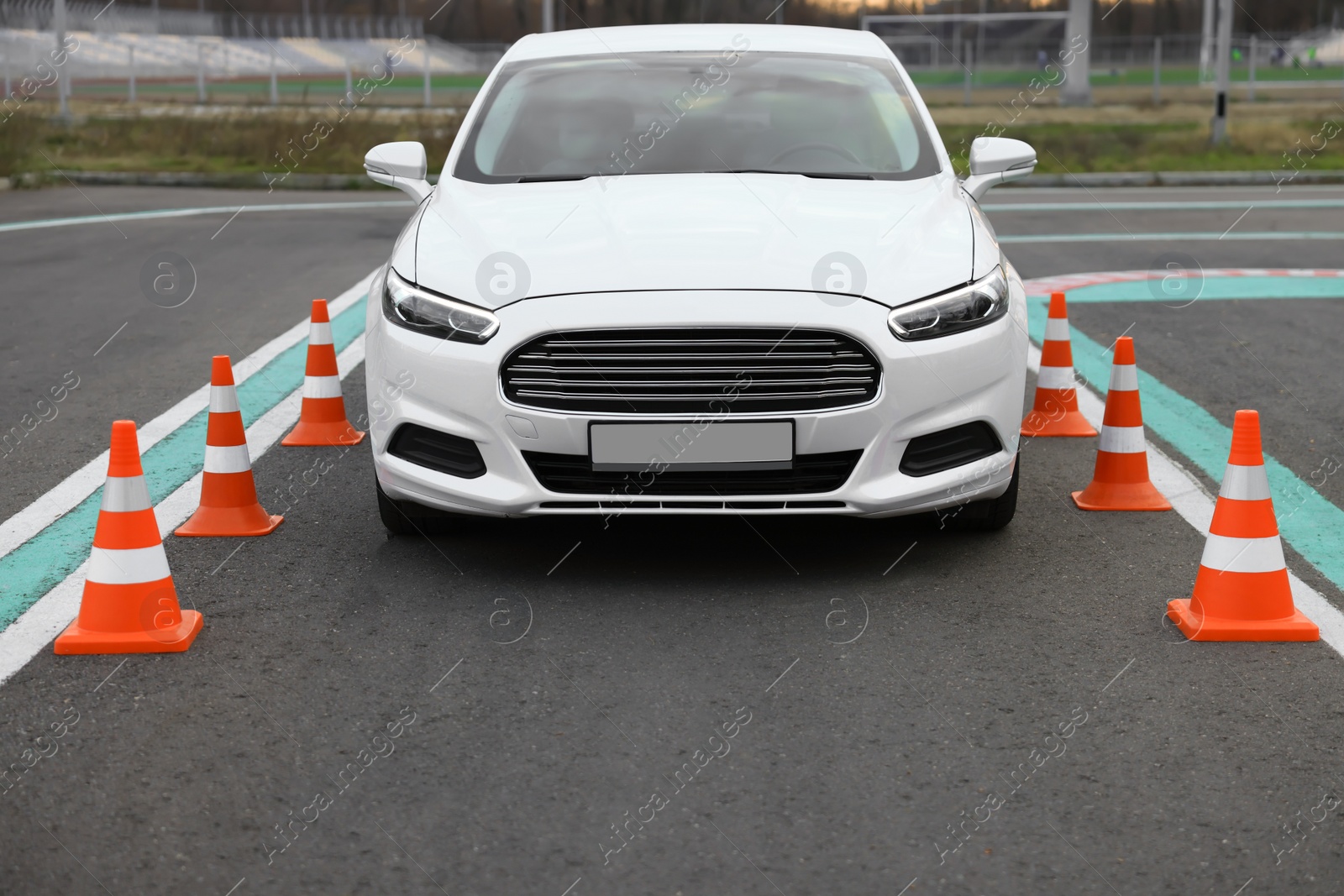 Photo of Modern car on driving school test track with traffic cones