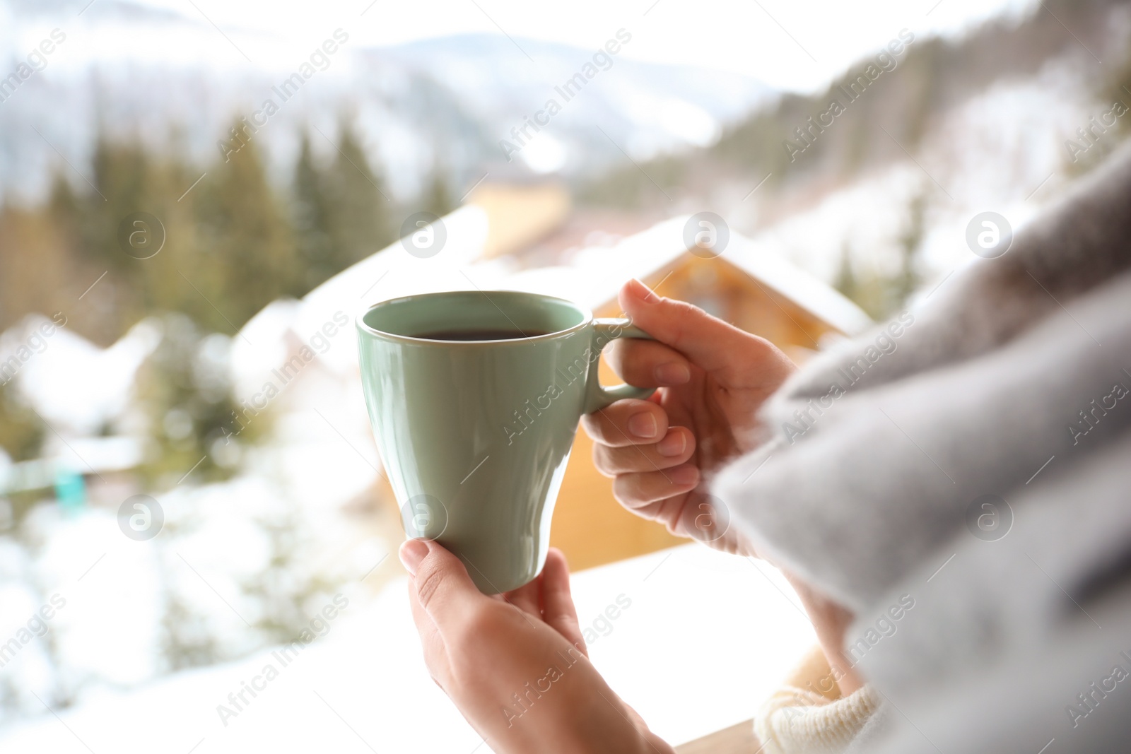 Photo of Woman with cup of tasty coffee outdoors on winter morning, closeup