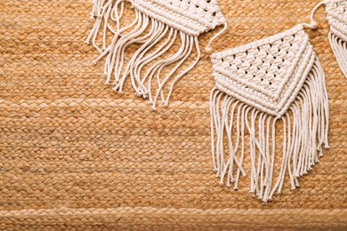 Photo of Large macrame on wicker straw background, flat lay. Space for text