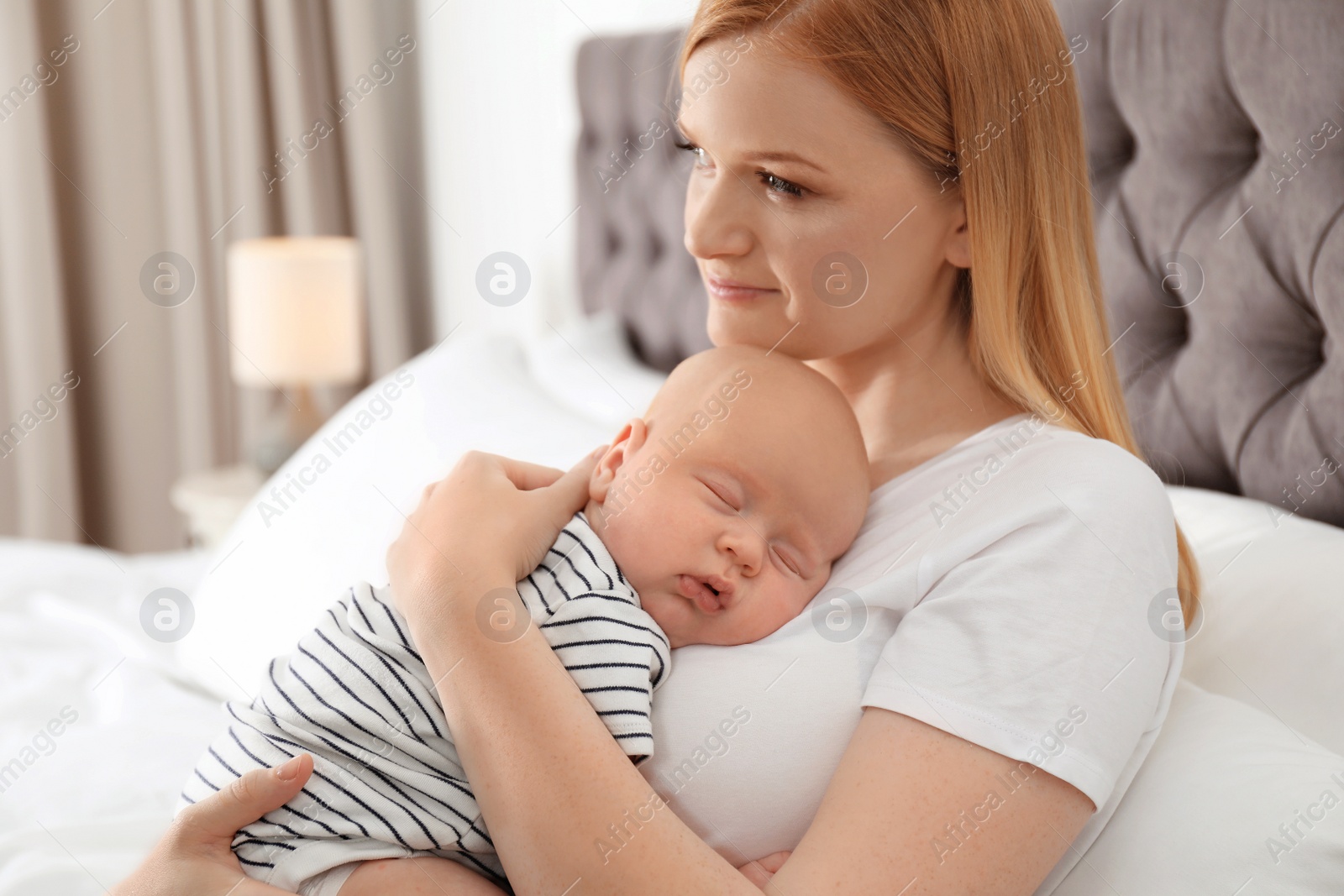 Photo of Mother with her sleeping baby in bedroom