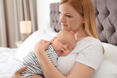 Mother with her sleeping baby in bedroom