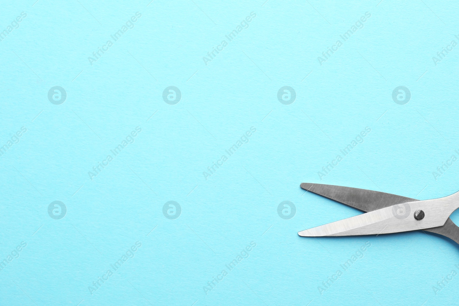 Photo of Pair of sharp scissors on color background, top view. Space for text