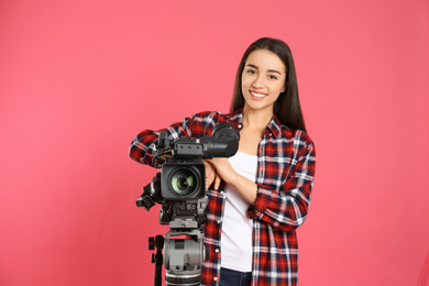 Photo of Operator with professional video camera on pink background