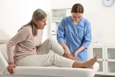 Photo of Arthritis symptoms. Doctor examining patient's leg in hospital