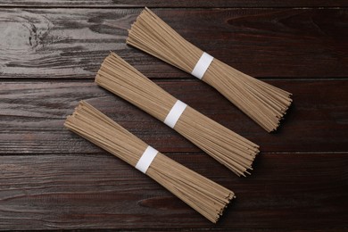 Uncooked buckwheat noodles (soba) on wooden table, flat lay