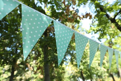 Light blue bunting flags in park. Party decor