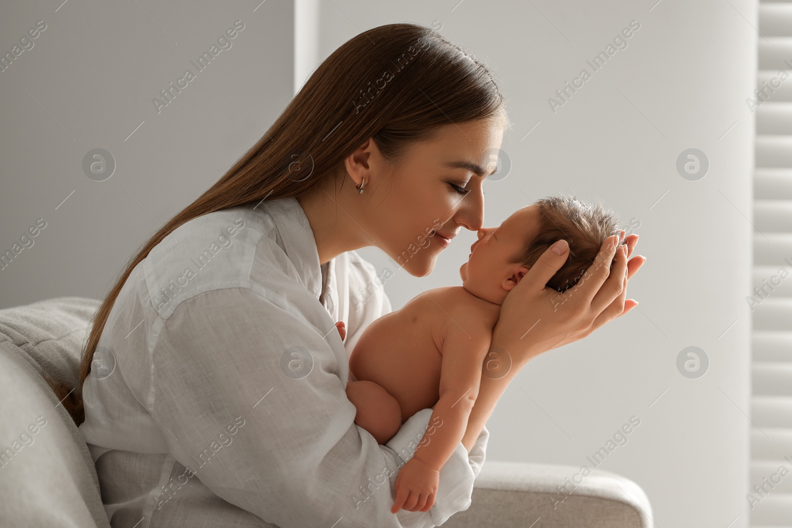 Photo of Mother holding her cute newborn baby indoors