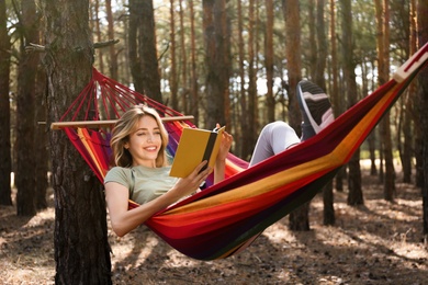 Photo of Woman with book relaxing in hammock outdoors on summer day