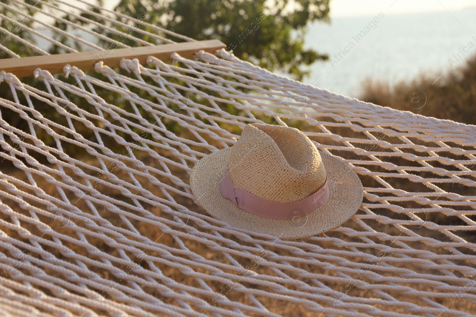 Photo of Hammock with hat hanging outdoors. Time to relax