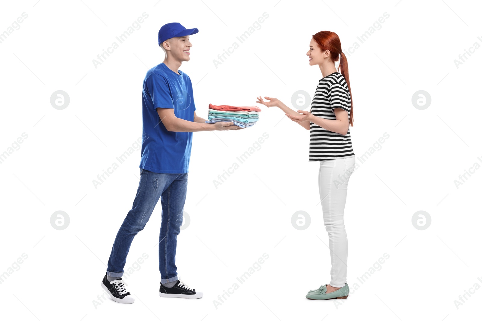 Image of Dry-cleaning delivery. Courier giving folded clothes to woman on white background