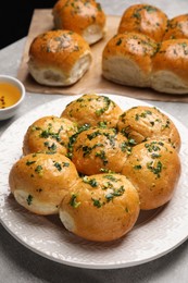 Photo of Traditional pampushka buns with garlic and herbs on grey table