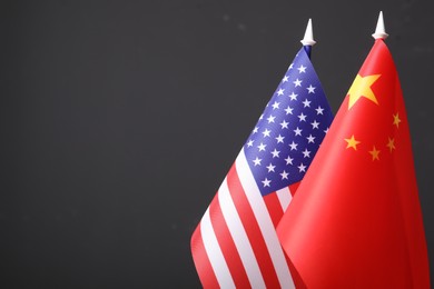Closeup view of USA and China flags on dark background, space for text. International relations