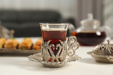 Cup of delicious Turkish tea served on white table, closeup