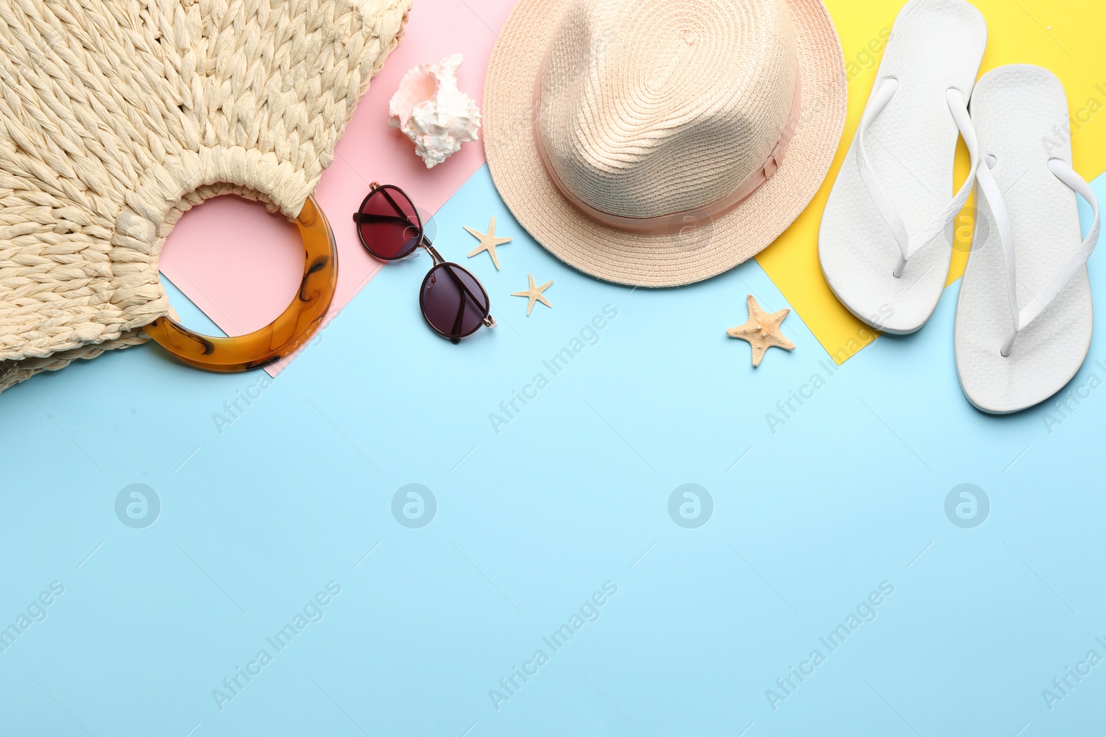 Photo of Beach accessories on light blue background, flat lay. Space for text