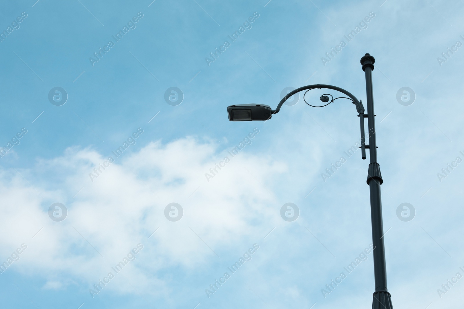 Photo of Street light lamp against cloudy sky, space for text