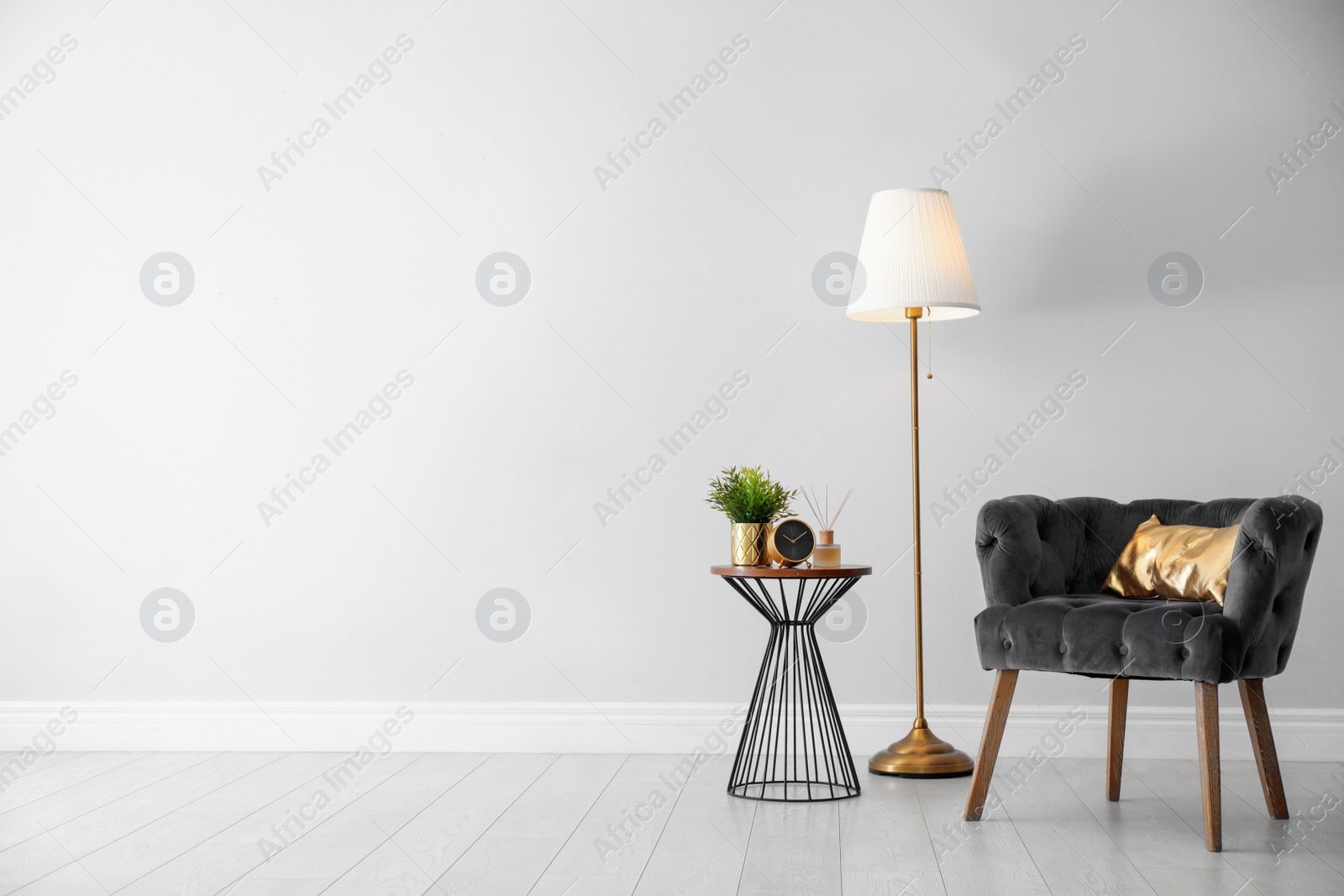 Photo of Stylish room interior with comfortable armchair, floor lamp near light wall, space for text