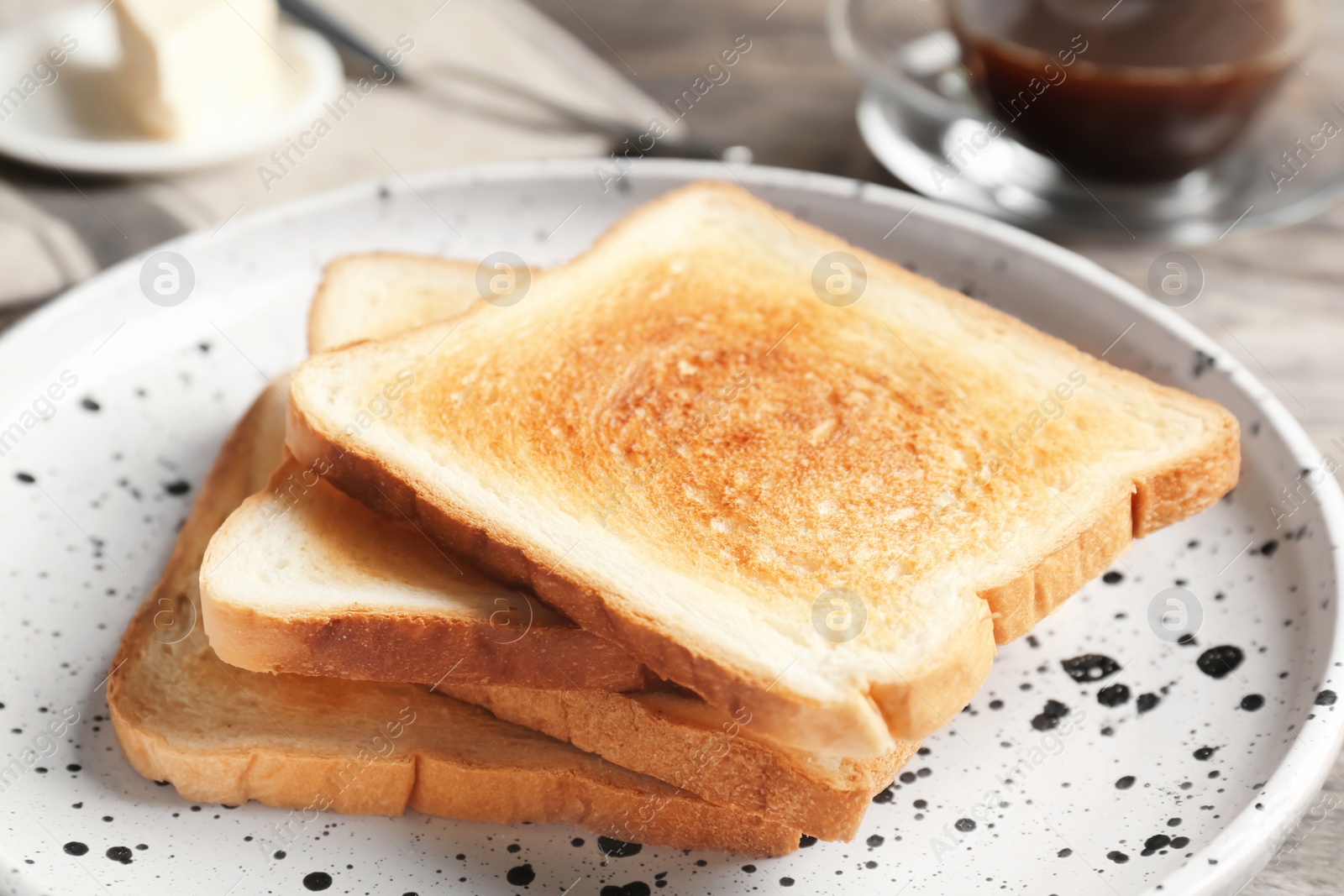 Photo of Plate with toasted bread on table, closeup