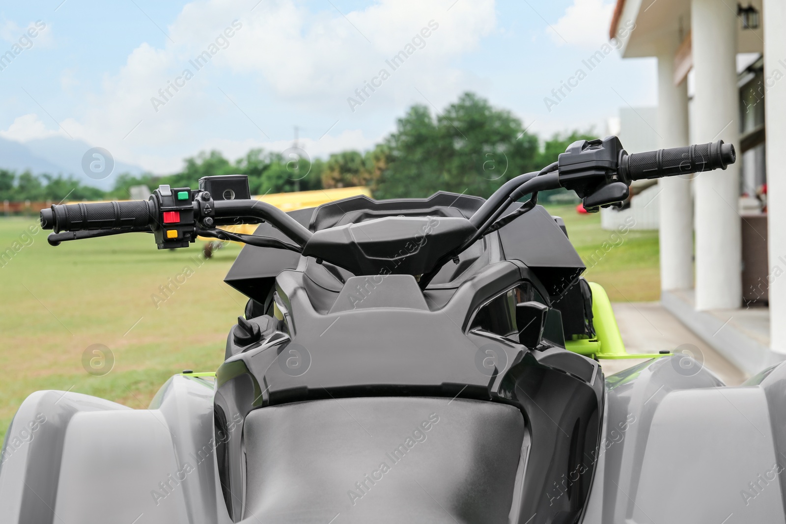 Photo of Modern quad bike on green grass in field, closeup