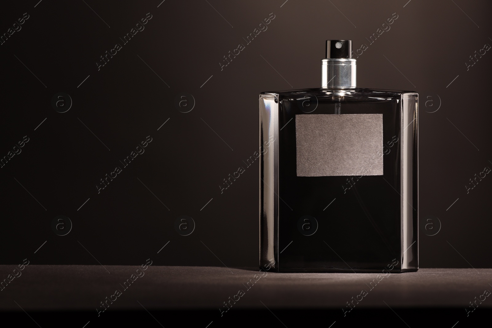 Photo of Luxury men`s perfume in bottle on grey table, space for text