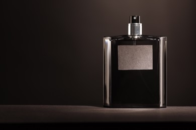 Luxury men`s perfume in bottle on grey table, space for text