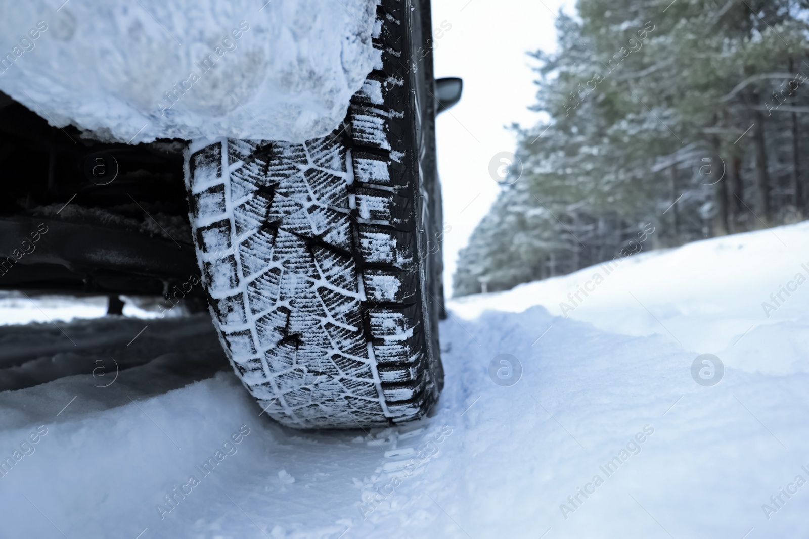 Photo of Snowy country road with car on winter day, closeup. Space for text