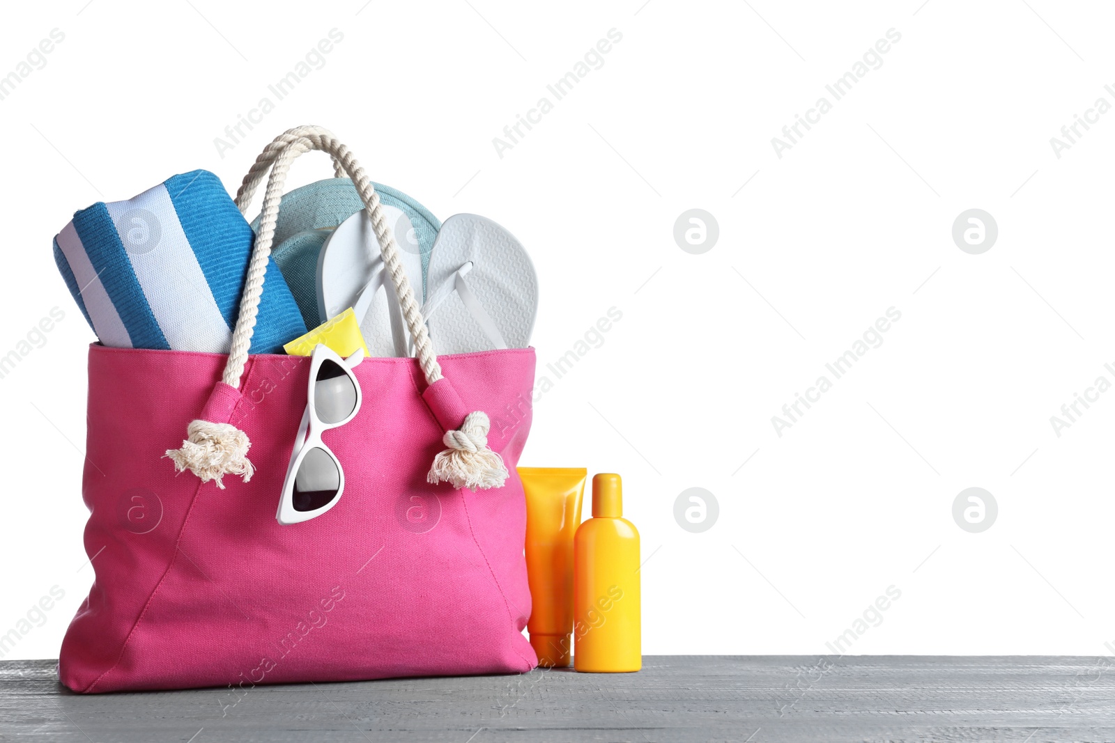 Photo of Composition with different beach objects on grey wooden table, white background